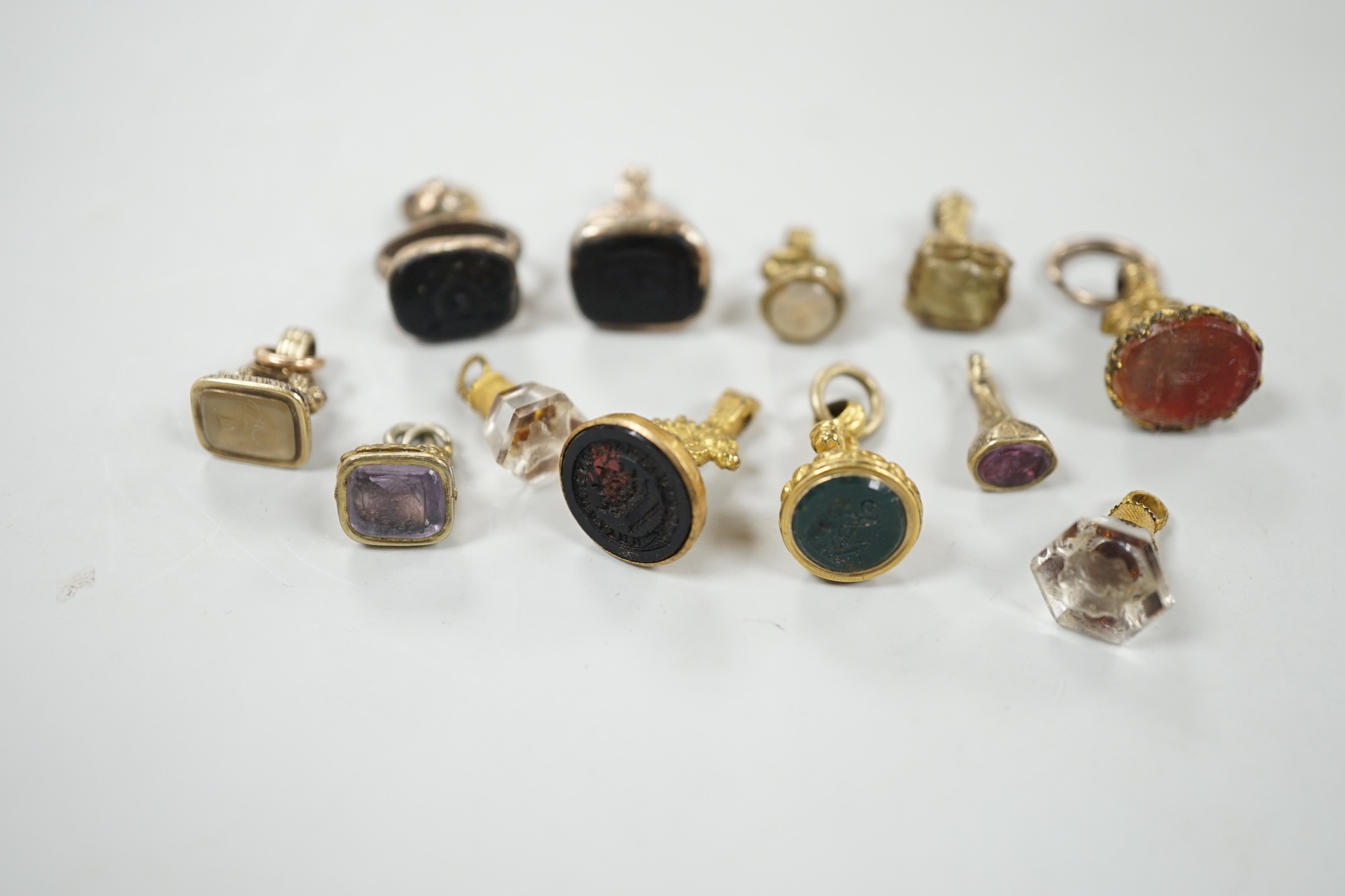 A collection of twelve small 19th century mainly yellow metal fob seals, with assorted matrices including bloodstone, amethyst, citrine and carnelian, largest 22mm.